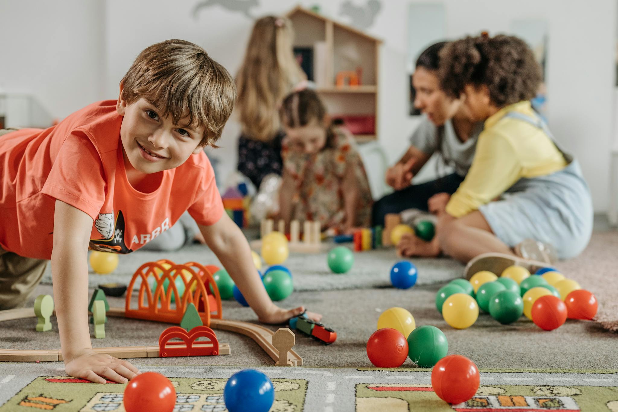 happy children and a caregiver playing with